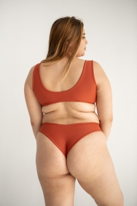 bodya ceglana góra stroju kąpielowego na modelce – szerokie ramiączka, sportowy fason, głęboki dekolt, widok z tyłu