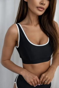 bodya czarna góra stroju kąpielowego na modelce – szerokie ramiączka, sportowy fason, z lamówką, widok z przodu
