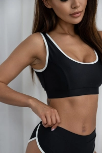 bodya czarna góra stroju kąpielowego na modelce – szerokie ramiączka, sportowy fason, z lamówką, widok z przodu