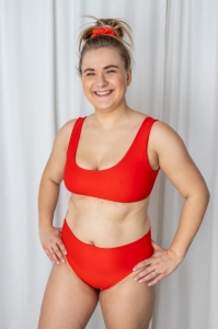 bodya czerwona góra stroju kąpielowego na modelce – szerokie ramiączka, sportowy fason, głęboki dekolt, widok z przodu