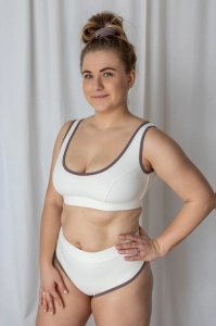 bodya biała góra stroju kąpielowego na modelce – szerokie ramiączka, sportowy fason, z lamówką, widok z przodu
