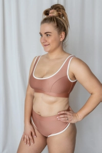 bodya różowa góra stroju kąpielowego na modelce – szerokie ramiączka, sportowy fason, z lamówką, widok z przodu