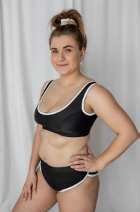 bodya czarna góra stroju kąpielowego na modelce – szerokie ramiączka, sportowy fason, z lamówką, widok z przodu