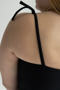 bodya czarny jednoczęściowy strój kąpielowy na modelce – klasyczny fason z głębokim dekoltem, wyszczuplający, wiązane ramiączka,  widok z tyłu