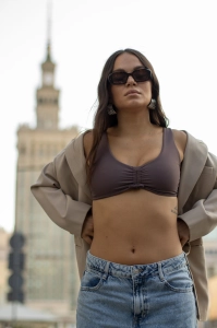 bodya fioletowa góra stroju kąpielowego na modelce – szerokie ramiączka, z marszczeniem, głęboki dekolt, widok z przodu